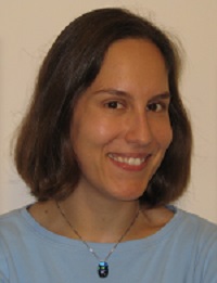 Headshot of Dr. Greenwald looking to the side, smiling, wearing a shiny necklace